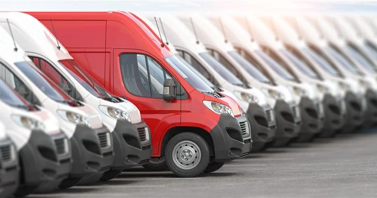 A row of fleet vans parked next to each other.